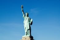 Iconic Statue of Liberty with vibrant blue sky backdrop, symbolizing freedom and hope.